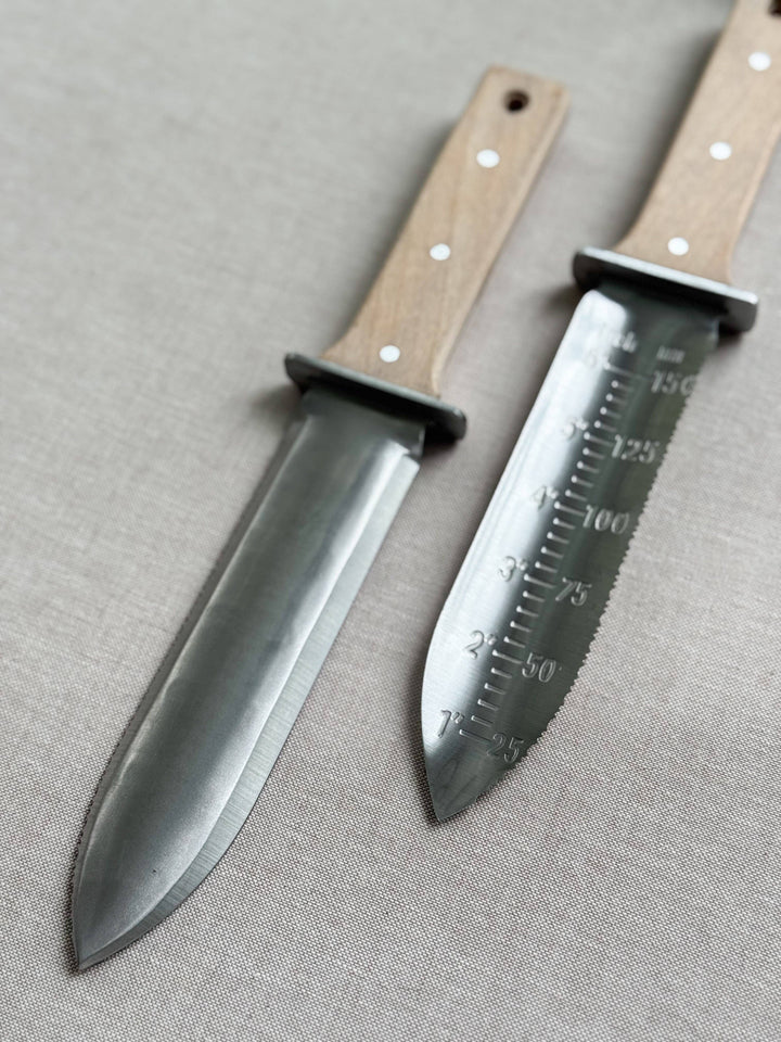 Two knives with wooden handles on a gray fabric background