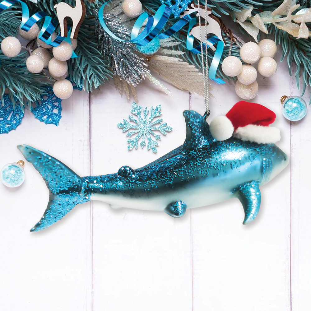 Decorative blue glittery dolphin ornament with a Santa hat on a festive background.