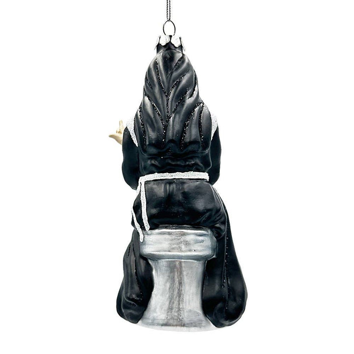 Decorative figurine of a woman in a black and white habit on a silver seat on white background