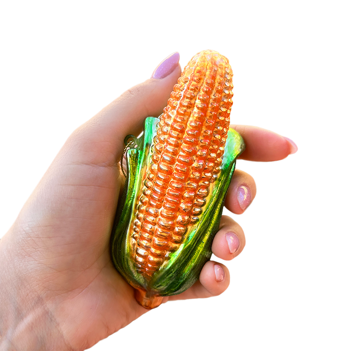 Corn-shaped keychain held in a hand against a white background