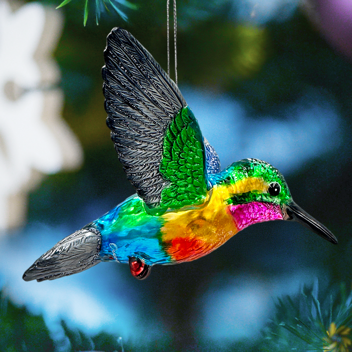 Colorful hummingbird-shaped ornament hanging against a blurred natural background