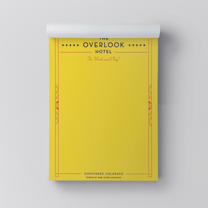 Yellow notepad with 'The Overlook Hotel' design on a gray background