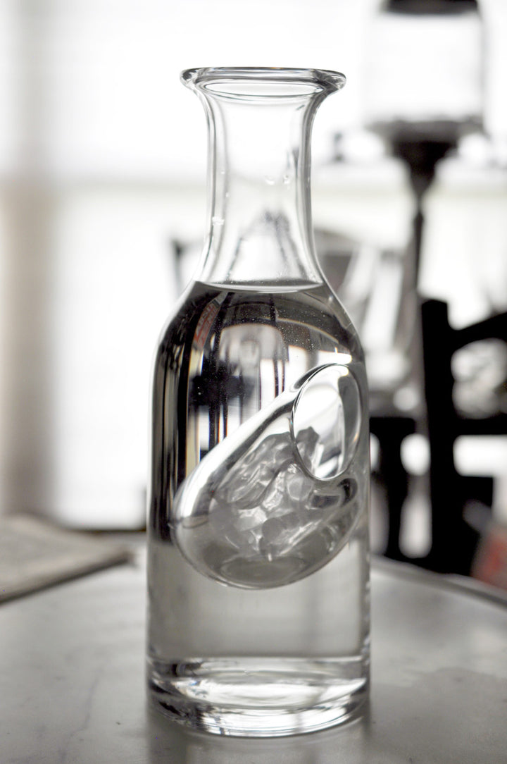 Clear glass carafe on a table with a blurred background