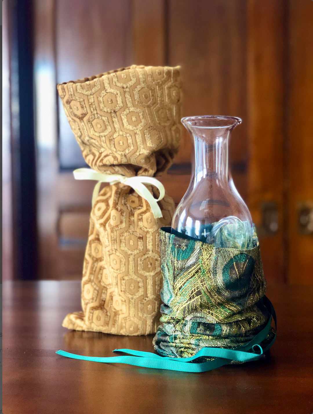 Glass ice carafe with fabric gift bag in gold pattern and a peacock feathers