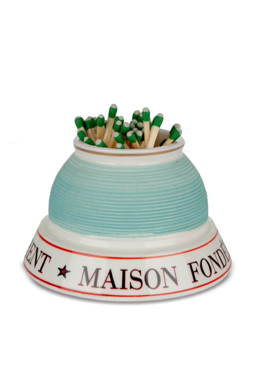 Matches in a ceramic holder with 'Maison Fondée" text on a white background