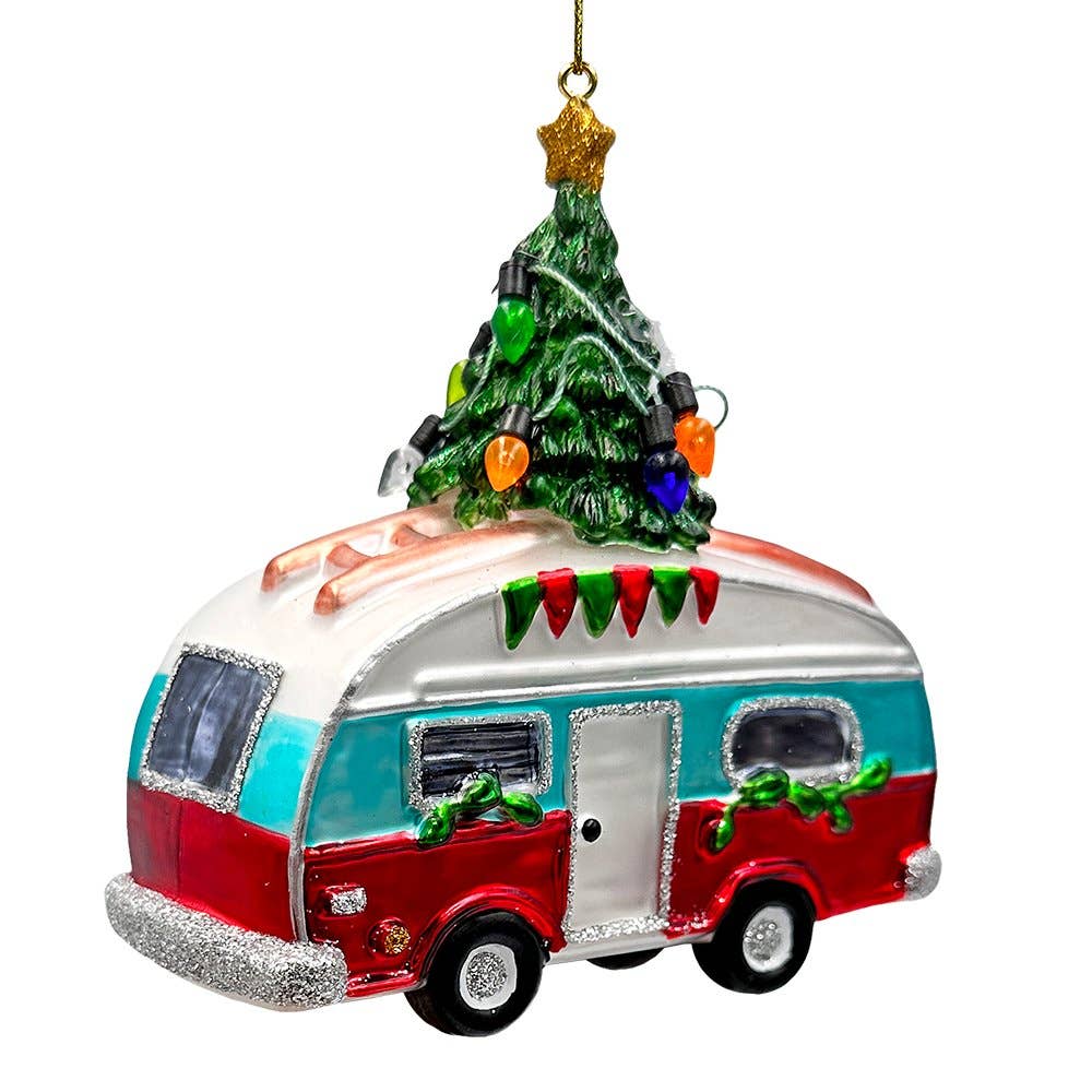 Decorative ornament of a camper with a Christmas tree on top against a white background