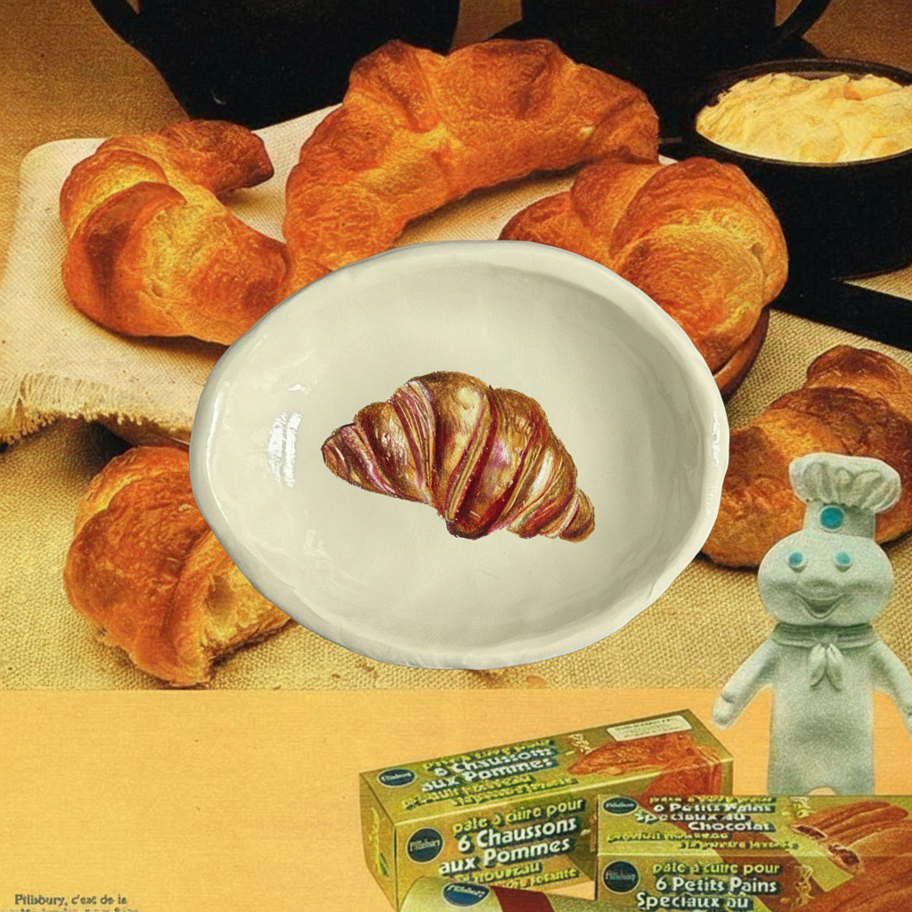 An old advertisement for Croissants with the Pillsbury doughman, with a trinket tray with croissant illustration