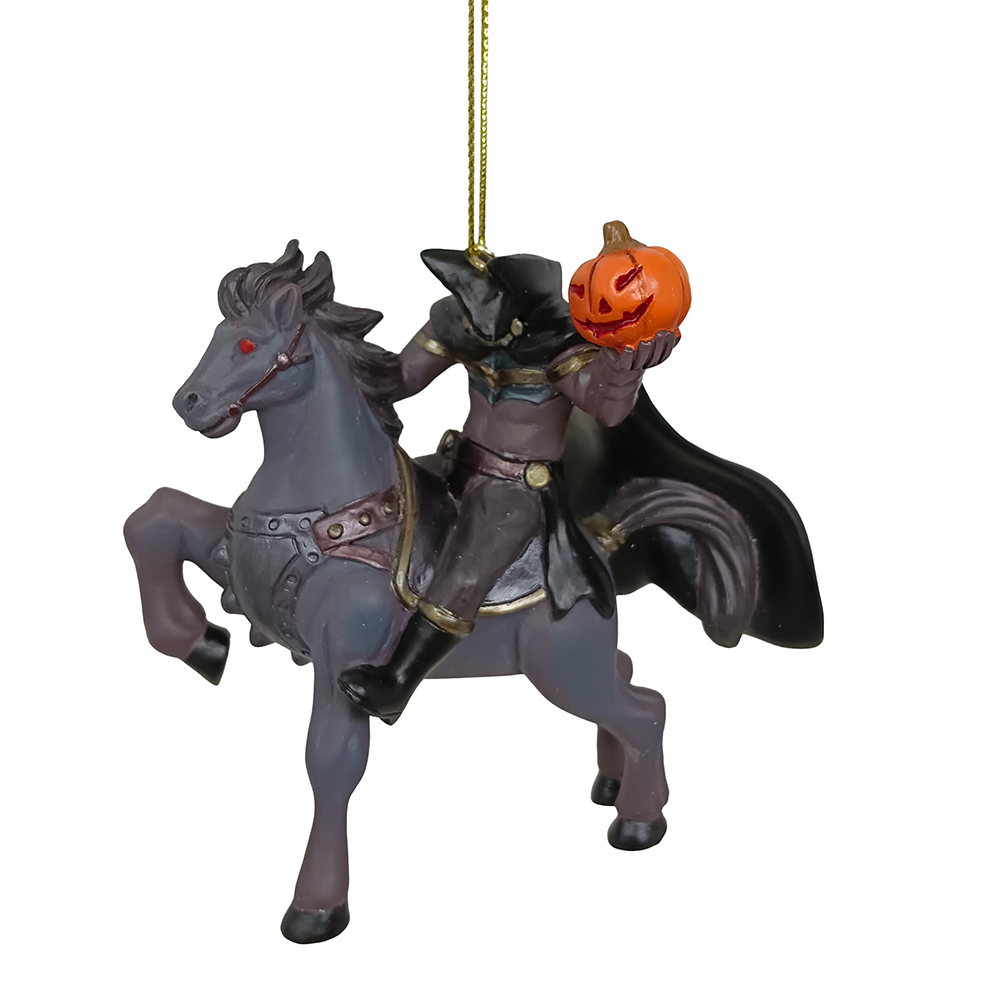 Decorative ornament of a figure on a horse with a pumpkin head, hanging from a gold string.