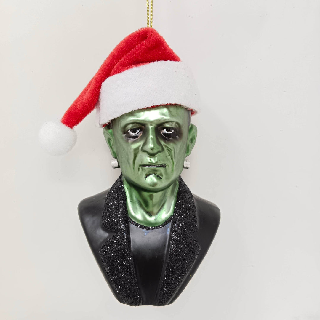 Ornament resembling a green horror creature with a Santa hat on a white background